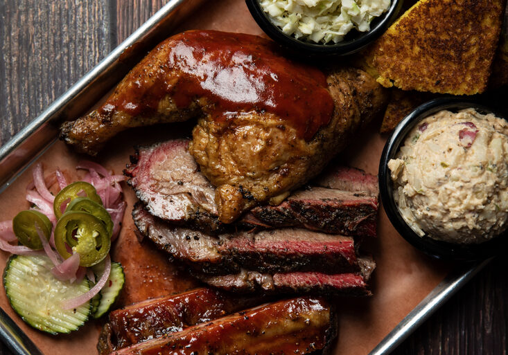 A tray of food with meat, sides and coleslaw.