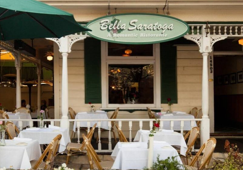 A restaurant with tables and chairs outside of it