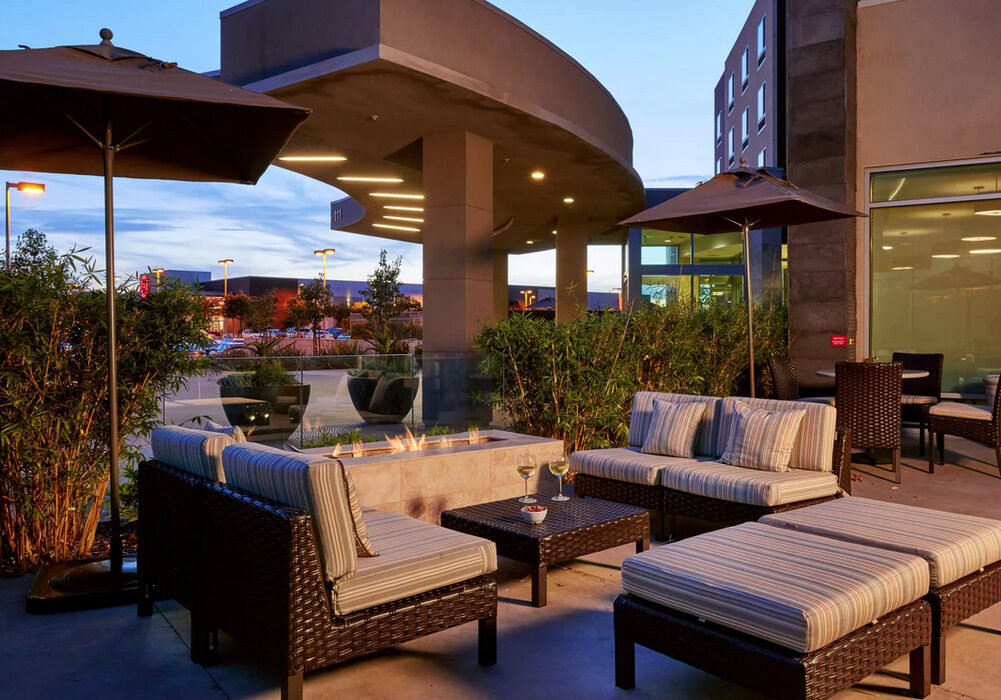 A patio with furniture and tables outside of it.