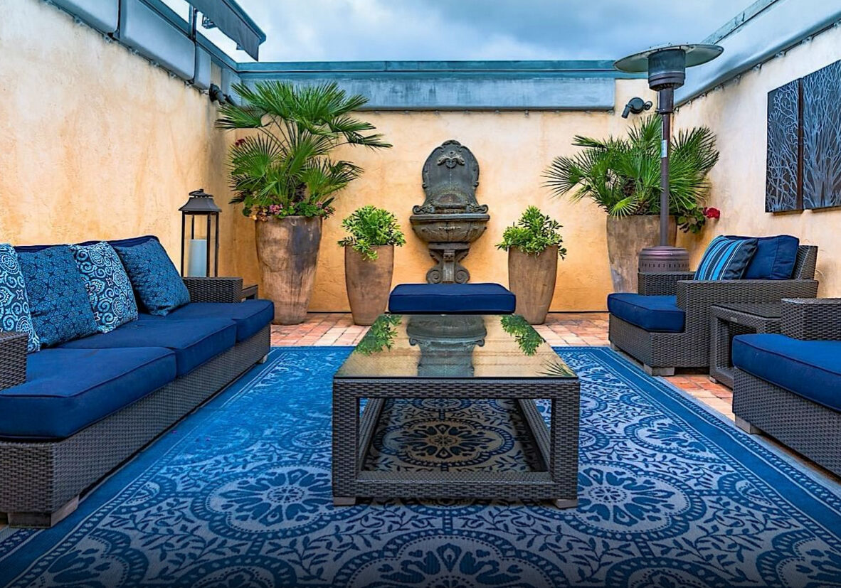 A blue patio with furniture and potted plants.