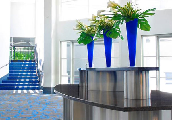 A room with blue vases and stairs in the background.