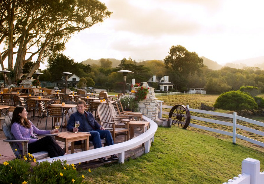 A man and woman sitting at an outdoor restaurant.