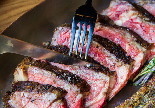 A fork is in the middle of some meat.