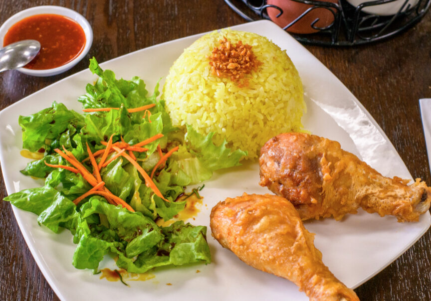 A plate of food with rice, salad and chicken.