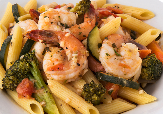 A plate of shrimp and pasta with broccoli.