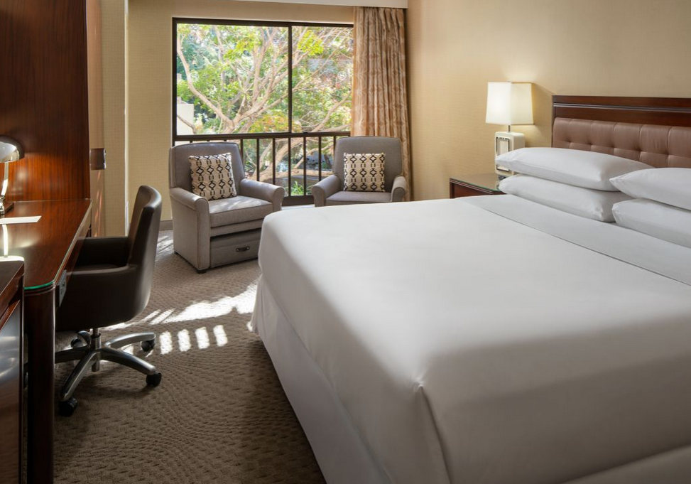 A hotel room with two beds and chairs.