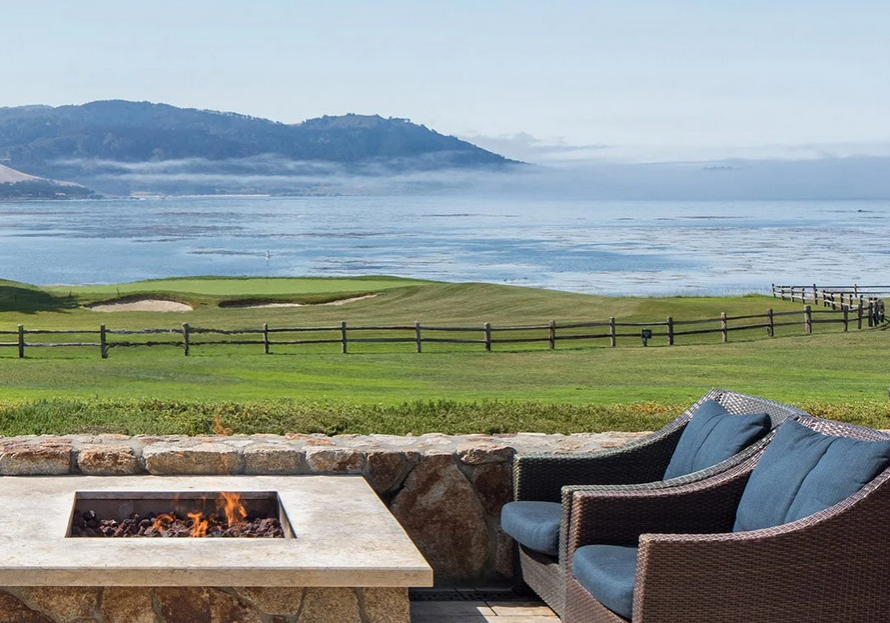 A fire pit sitting next to a grassy field.