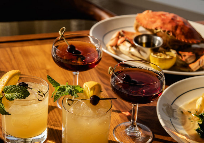 A table with several different drinks and food.