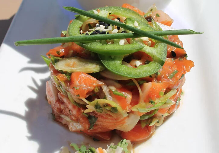 A salad with carrots, cucumber and green onions.